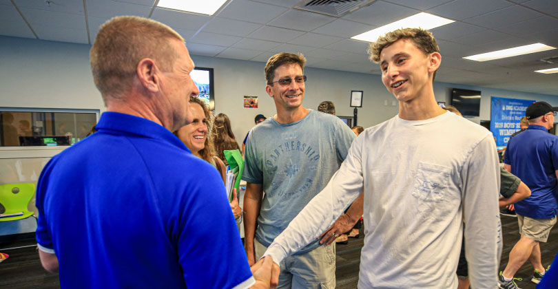athlete and parents talking with a college coach athlete and parents talking with a college coach